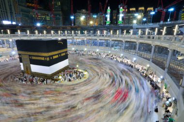 Umra ya da Hac zamanlarında Mekke 'deki Kutsal Kabe' nin etrafında Tawaf yapan bir grup insan Mescid-i Haram 'ın tepesinden bakıyor. Geceleri uzun pozlama