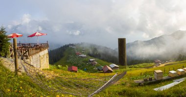 Dağlık arazide geleneksel ahşap evler. Manzara fotoğrafı Türkiye 'nin Pokut, Rize, Karadeniz / Karadeniz bölgesinde çekildi. Pokut, Rize 'nin en yüksek rakımlı tatil beldelerinden biridir..