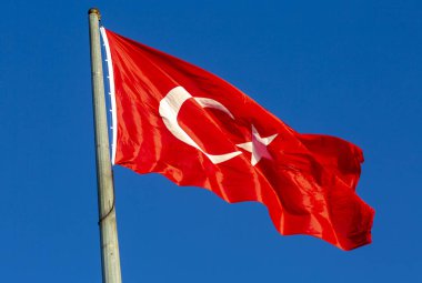 Mavi gökyüzünde dalgalanan Türk bayrağı.