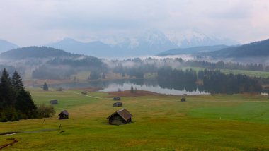 Orman kenarında dağ çayırında küçük bir kulübe, Geroldsee arka planda Karwendel Dağları gündoğumunda, Kaltenbrunn, Yukarı Bavyera, Almanya