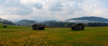 Orman kenarında dağ çayırında küçük bir kulübe, Geroldsee arka planda Karwendel Dağları gündoğumunda, Kaltenbrunn, Yukarı Bavyera, Almanya