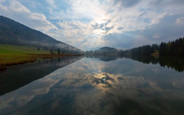 Orman kenarında dağ çayırında küçük bir kulübe, Geroldsee arka planda Karwendel Dağları gündoğumunda, Kaltenbrunn, Yukarı Bavyera, Almanya