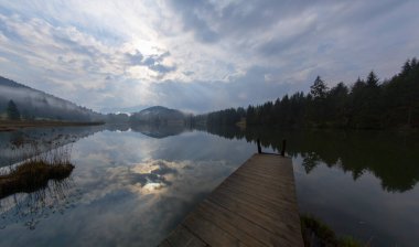Orman kenarında dağ çayırında küçük bir kulübe, Geroldsee arka planda Karwendel Dağları gündoğumunda, Kaltenbrunn, Yukarı Bavyera, Almanya