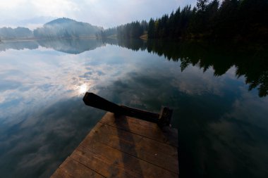 Orman kenarında dağ çayırında küçük bir kulübe, Geroldsee arka planda Karwendel Dağları gündoğumunda, Kaltenbrunn, Yukarı Bavyera, Almanya