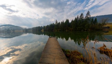 Orman kenarında dağ çayırında küçük bir kulübe, Geroldsee arka planda Karwendel Dağları gündoğumunda, Kaltenbrunn, Yukarı Bavyera, Almanya