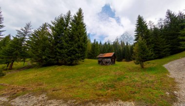 Orman kenarında dağ çayırında küçük bir kulübe, Geroldsee arka planda Karwendel Dağları gündoğumunda, Kaltenbrunn, Yukarı Bavyera, Almanya