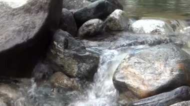 Güçlü şeffaf bir deresi olan vahşi bir dağ nehri. Akıntıda kaya parçaları olan geveze bir akıntının detaylı statik görüntüsü. Hızla akan suda kayalar..