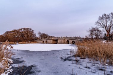 Changchun, Çin 'deki Kuzey Gölü Ulusal Wetland Parkı' nın kış manzarası gün batımının altında.