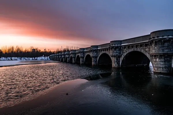 Changchun, Çin 'deki Kuzey Gölü Ulusal Wetland Parkı' nın kış manzarası gün batımının altında.