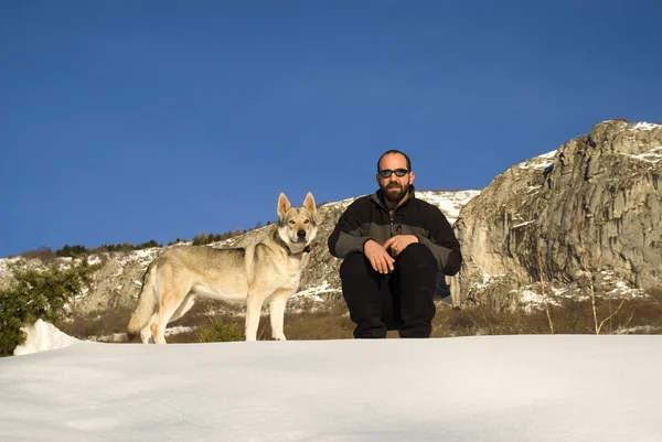 Homme avec chien dans la forêt d'hiver — Photo