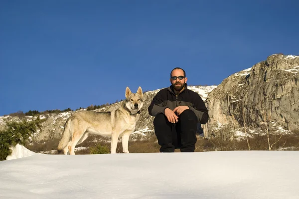 Uomo con cane nella foresta invernale — Foto Stock