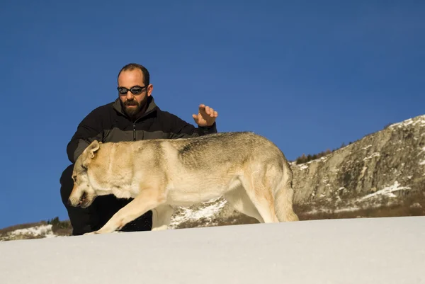 Homme avec chien dans la forêt d'hiver — Photo