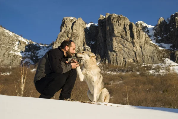 Man med hund i vinter skog — Stockfoto