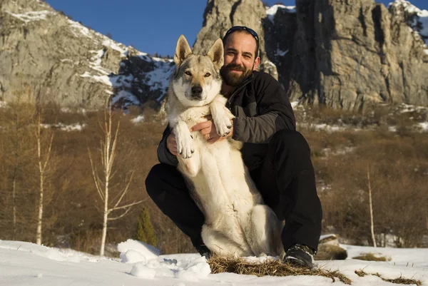 Uomo con cane nella foresta invernale — Foto Stock