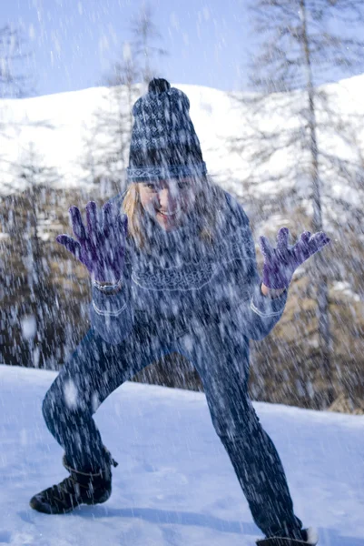 Verspielte Frau wirft Schnee in Wald — Stockfoto