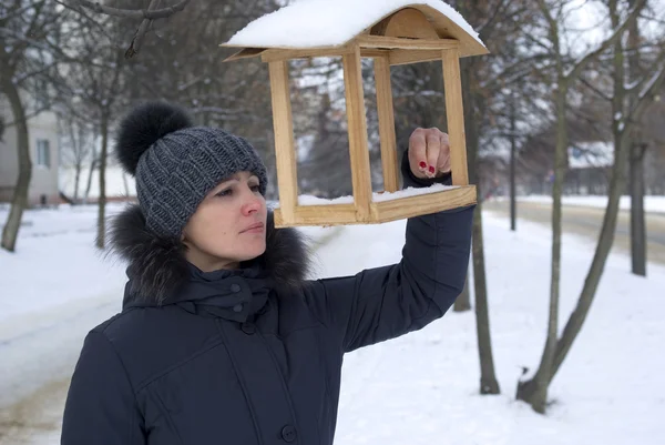 Mulher examinando uma casa de pássaros no parque da cidade — Fotografia de Stock