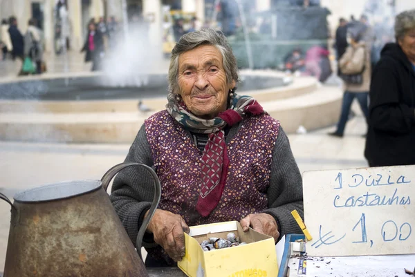 Arme bejaarde vrouw verkoopt kastanjes — Stockfoto