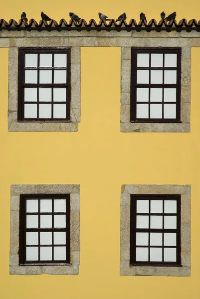 Fenster an einer gelben Fassade — Stockfoto