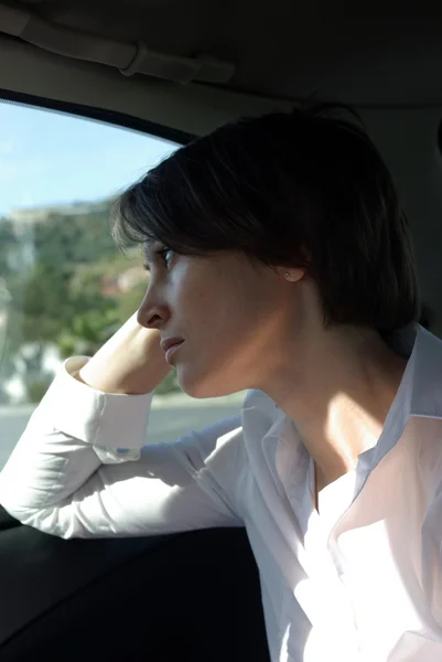 Surullinen nainen autossa — kuvapankkivalokuva
