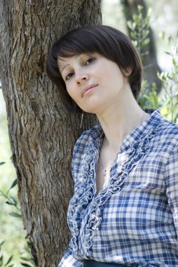 kadına karşı ağaca yaslanmış