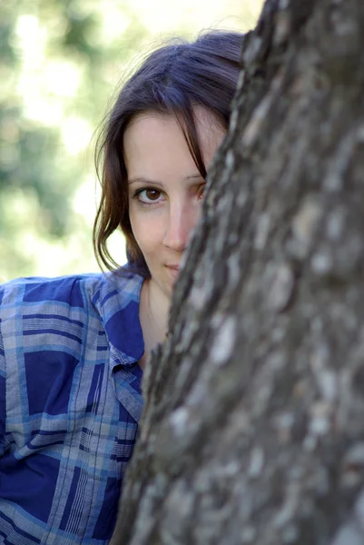 La mujer se esconde de un árbol — Foto de Stock