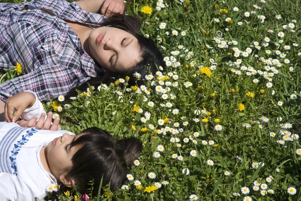 Meninas dormindo relaxante na grama com os olhos fechados — Fotografia de Stock