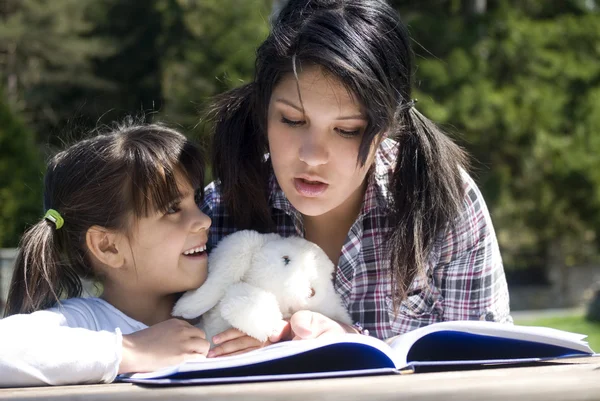 Sisters reading book together — Stock Photo, Image