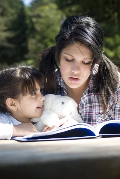 Sisters reading book together — Stock Photo, Image
