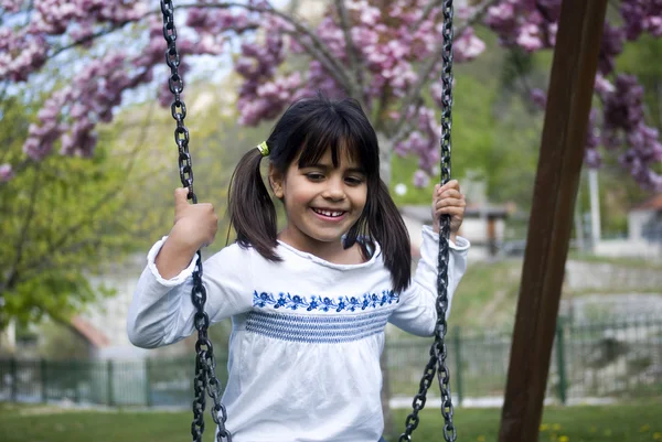 若いです女の子座ってスイング — ストック写真