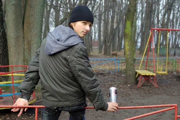 Chłopiec siedzi na placu zabaw, picie piwa — Zdjęcie stockowe