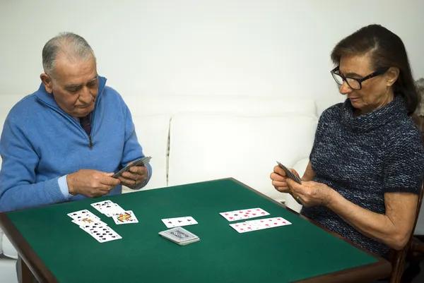 Casal de idosos jogando um jogo de cartas — Fotografia de Stock