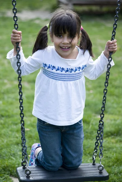 Flicka stående på swing — Stockfoto