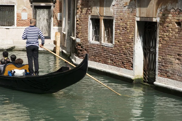 Gondolier rowing gondola in canal — Stock Photo, Image