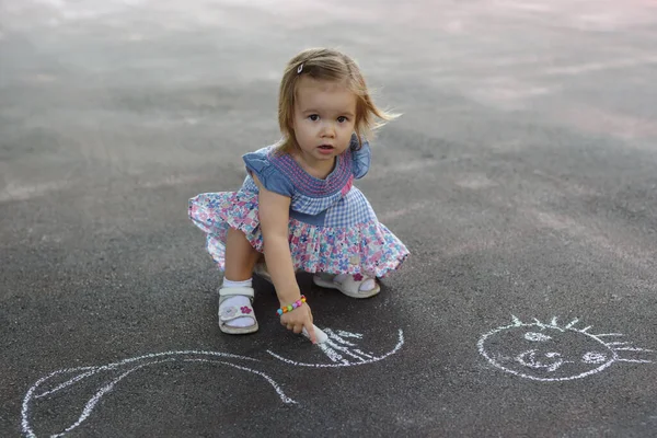 一个小女孩在人行道上用彩色粉笔潦草乱画的头像照片 — 图库照片