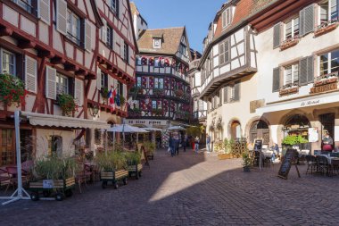 Colmar, Fransa - 24 Ekim 2021: Colmar 'ın tarihi merkezinde, iyi korunmuş yarı ahşap binaların etrafını çevreleyen yaya caddesi boyunca bakın