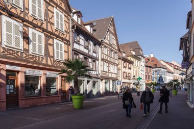 Colmar, Fransa - 24 Ekim 2021: Colmar 'ın tarihi merkezinde, iyi korunmuş yarı ahşap binaların etrafını çevreleyen yaya caddesi boyunca bakın