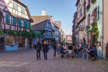 Riquewihr, Fransa - 24 Ekim 2021: Ortaçağ Riquewihr köyündeki ana yaya sokağı boyunca iyi korunmuş yarı ağaçlandırılmış binalar, Doğu Fransa 'nın Alsace bölgesi