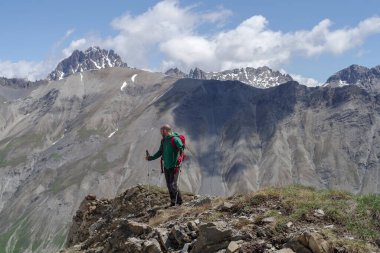 Mountain hiker standing on peak, Cottian Alps, Italy