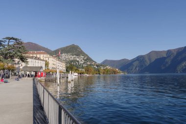 Lugano şehri Lugano Gölü, İsviçre kantonu Ticino, ana caddeden göl ve binalar manzaralı.