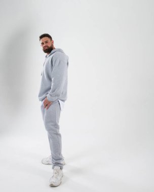 Beyaz arka planda açık renk takım elbiseli bir adamın tam boy portresi.