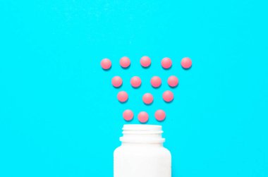 Mavi arka plandaki kavanozdan kırmızı haplar. Yüksek kalite fotoğraf