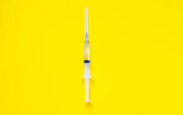 黄色の背景ミニマリズムの注射器 高品質の写真 — ストック写真