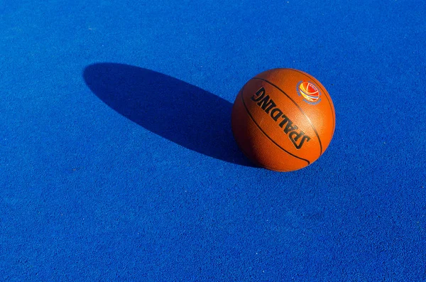 褐色的球在阳光灿烂的蓝天洒在蓝色的球场上 高质量的照片 免版税图库照片