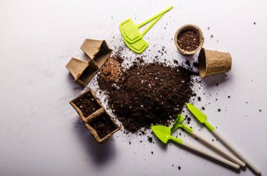 Beyaz arka planda bahçe aletleri ile ekilen toprak. Üst Manzara. Yüksek kalite