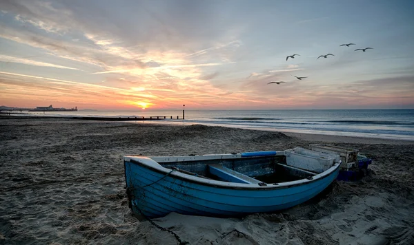 Barco azul na praia ao nascer do sol em Bournemouth — Fotografia de Stock