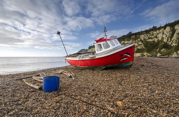 Barco de pesca vermelho na praia em cerveja em Devon — Fotografia de Stock