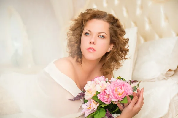 Schöne junge Plus-Size-Frau mit blauen Augen im Bett liegend — Stockfoto