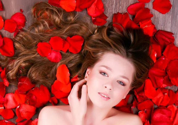 Girl laying in petals of roses — Stock Photo, Image