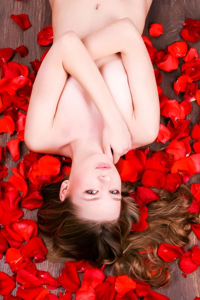 Mujer tendida en pétalos de rosas — Foto de Stock