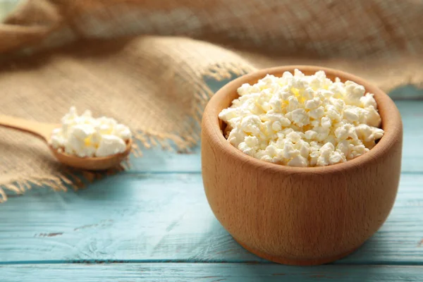 Kahvaltı için süzme peynir mavi arka planda ahşap kasede. Üst görünüm